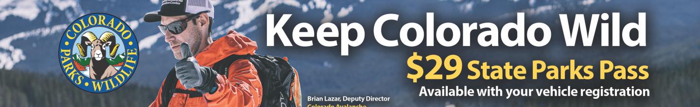 CAIC forecaster in orange coat giving thumbs up with "Keep Colorado Wild Pass" on it. 