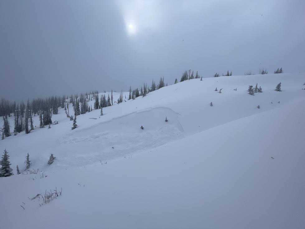 Looking through stormy weather at an avalanche in the distance