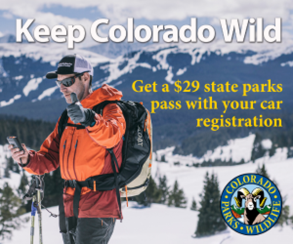 Avalanche forecaster in orange coat giving thumbs up with "keep colorado wild" text